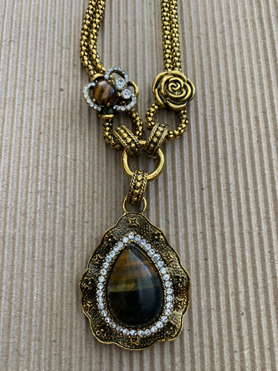Yellow Gold Tone Necklace Featuring an Ornate Tiger Eye Pendant